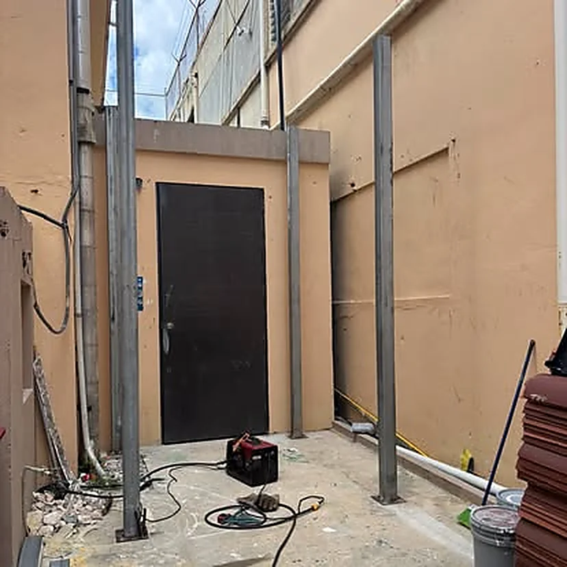 Puerta de seguridad metálica instalada con marco estructural de acero