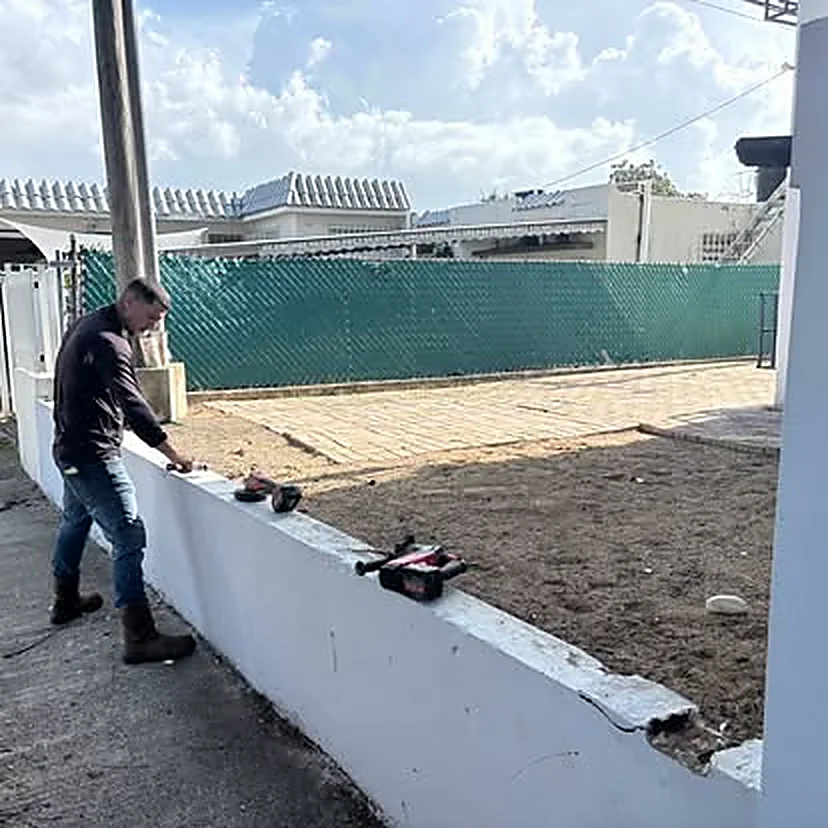 Trabajador de M&E dando acabado a una verja perimetral de hormigón